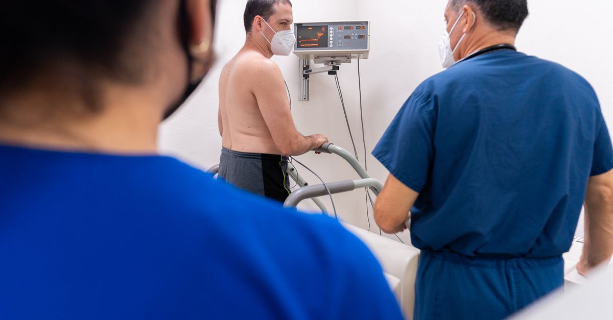 Arzt überwacht einen Patienten während eines Belastungs-EKGs auf einem Fahrradergometer in einer medizinischen Praxis